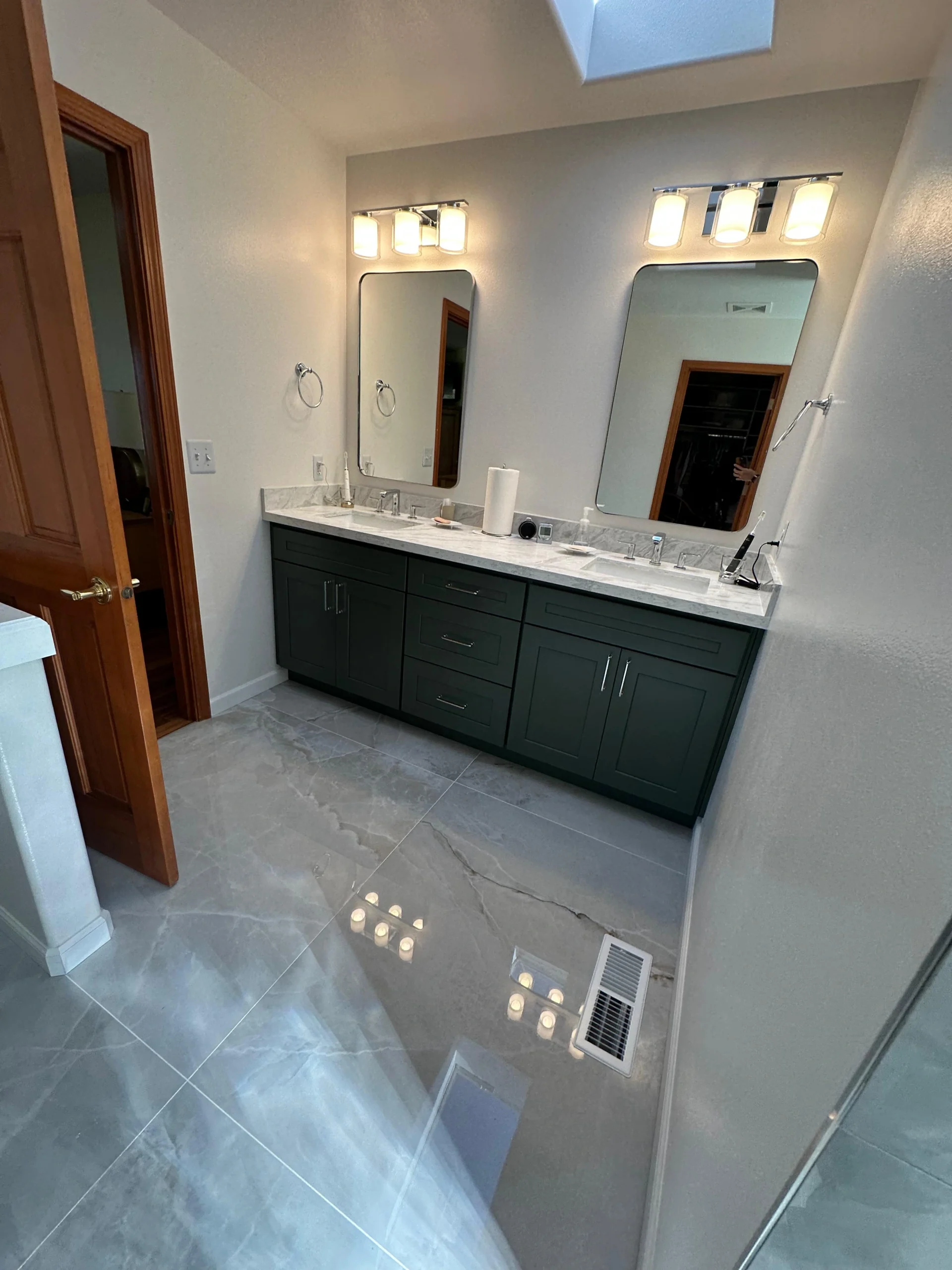 Dual-sink green vanity with marble counters in a Complete Master Bathroom Remodel.